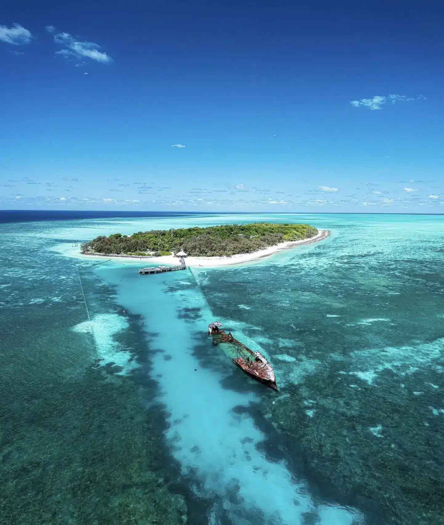 Aerial view of a small reef island and turquoise channel off the Australian coast