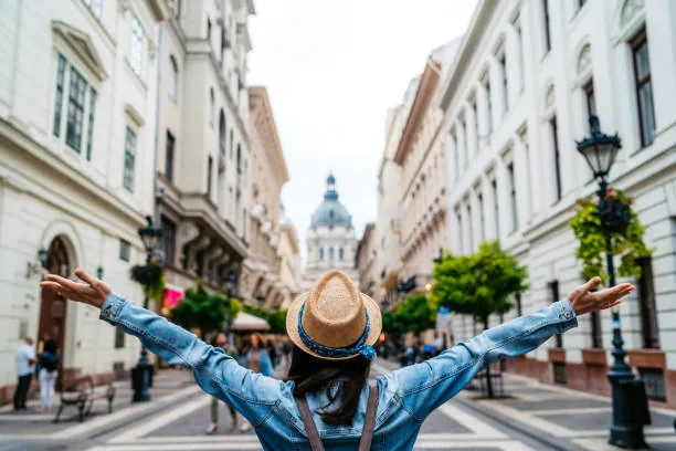 Traveller with arms outstretched on a historic European city street