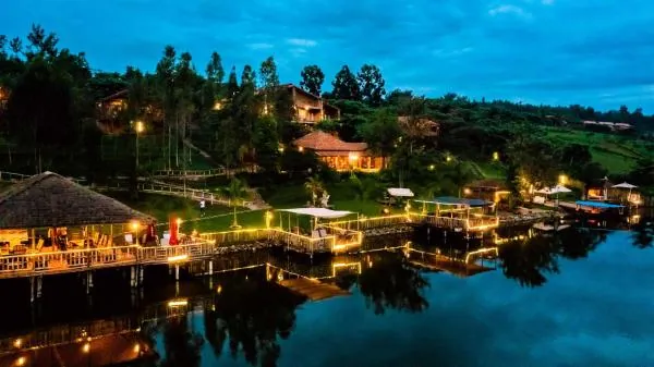 Lakeside resort with a jetty and restaurant lit at dusk in Rwanda